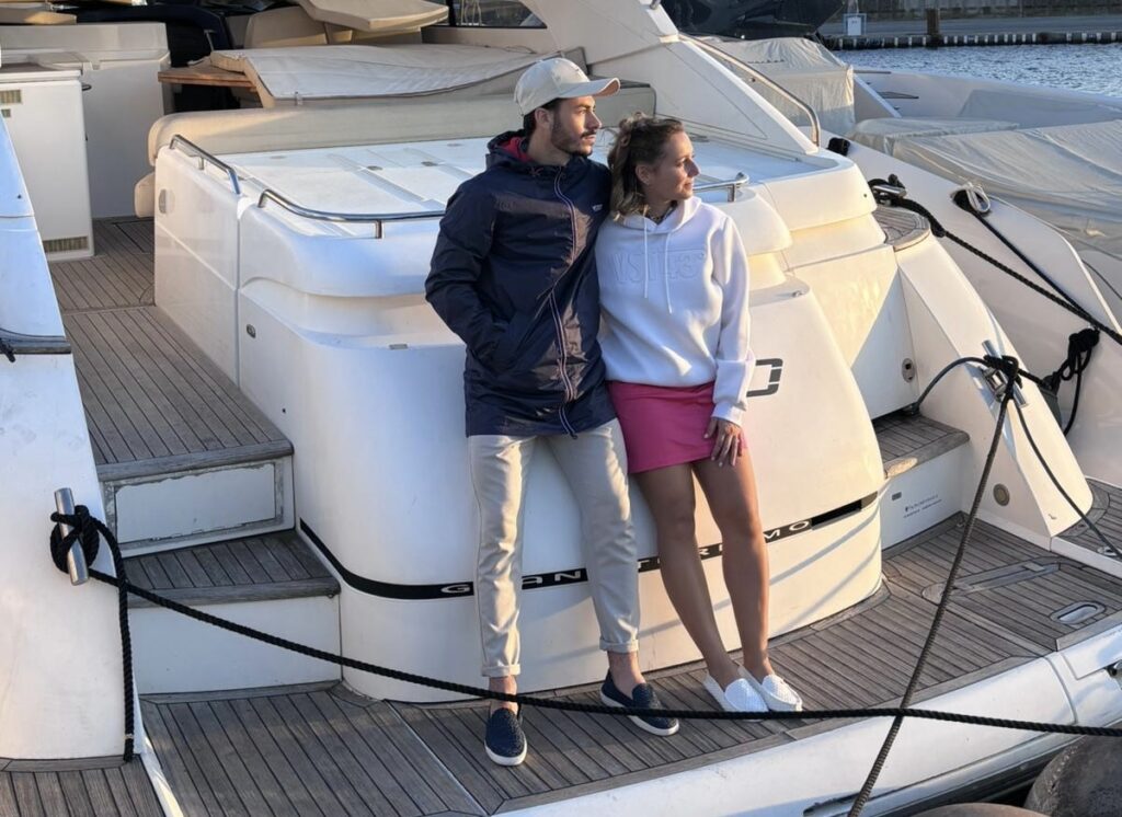 Un couple en tenues VST43° à la poupe d’un yacht, sur le port