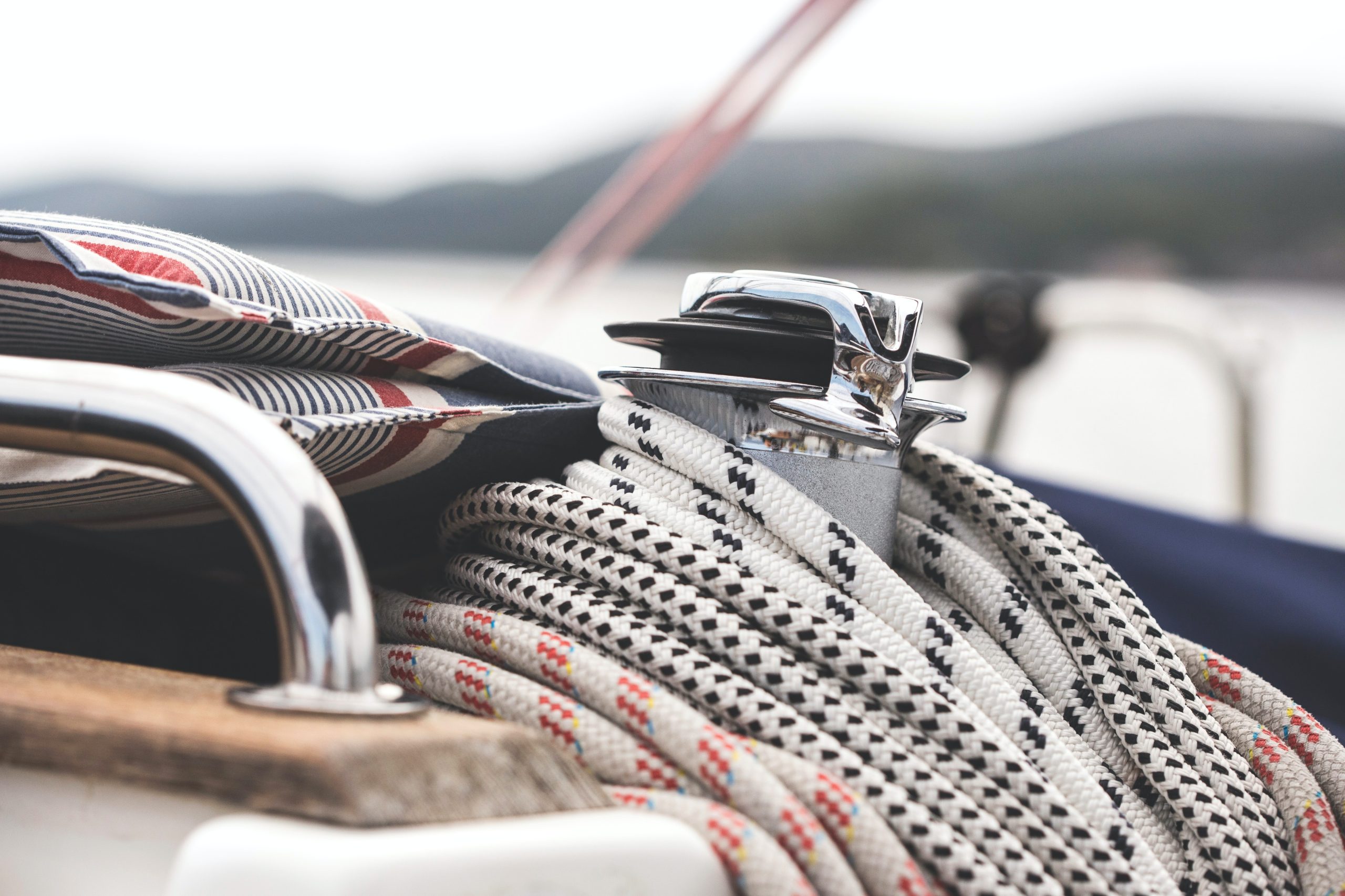 Écoute, winch et coussin rayé sur le pont d’un voilier